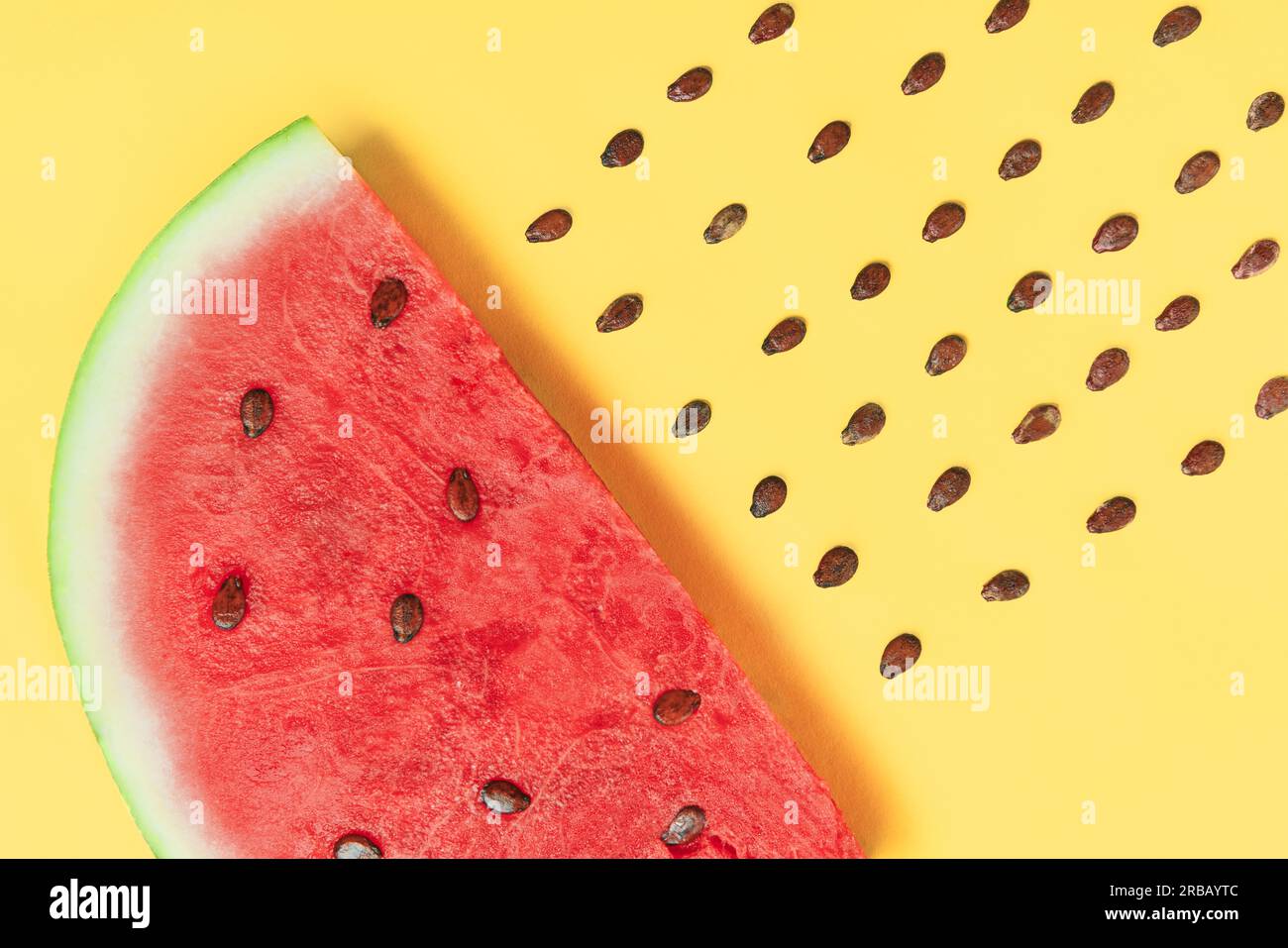 Wassermelonenscheibe mit Samen auf gelbem Hintergrund. Kreatives Layout. Food Art. Flat Lay Stockfoto