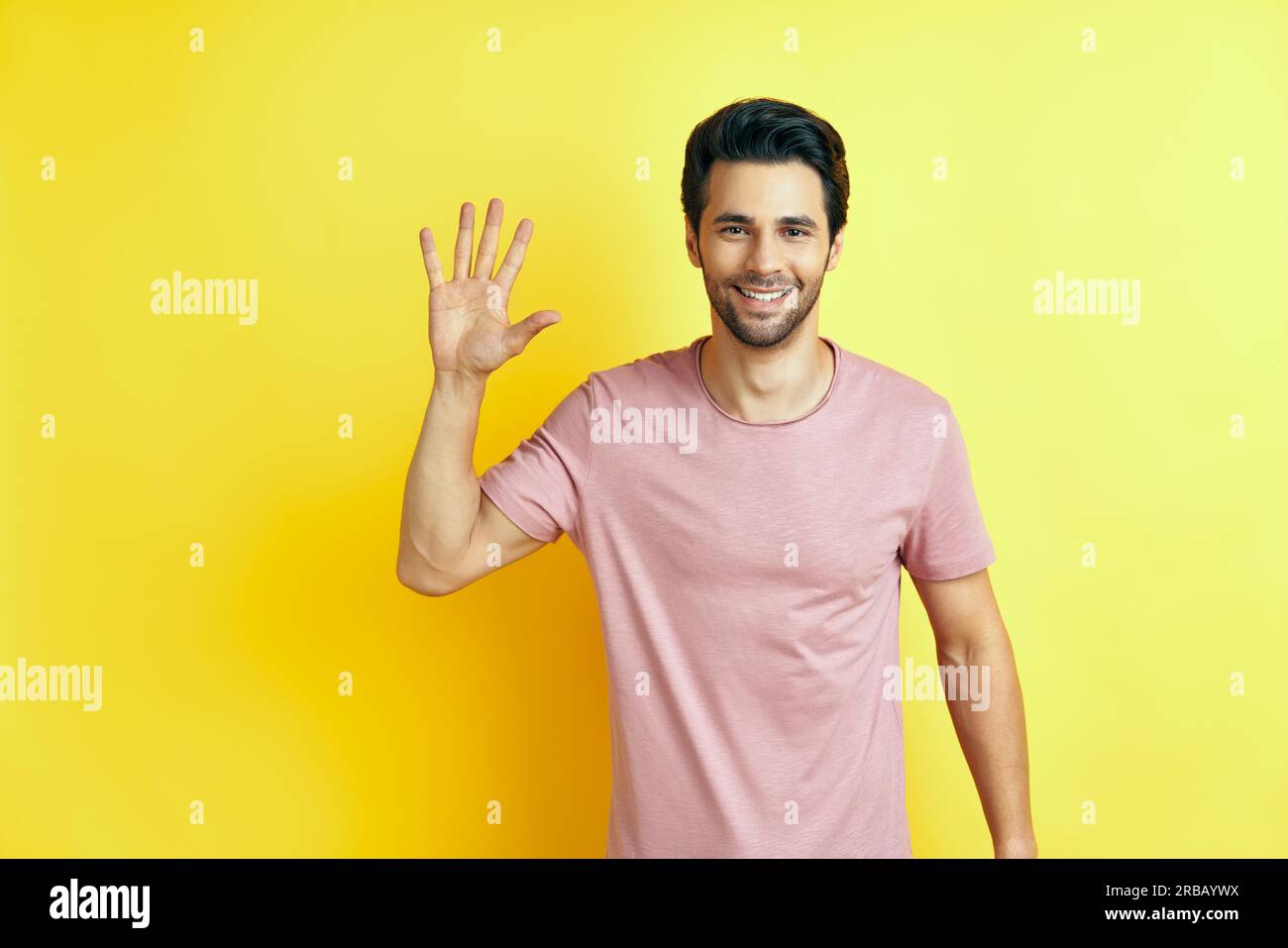 Portrait eines lächelnden Mannes mit erhobener Hand in der Begrüßung. High Five, Hello-Konzept Stockfoto