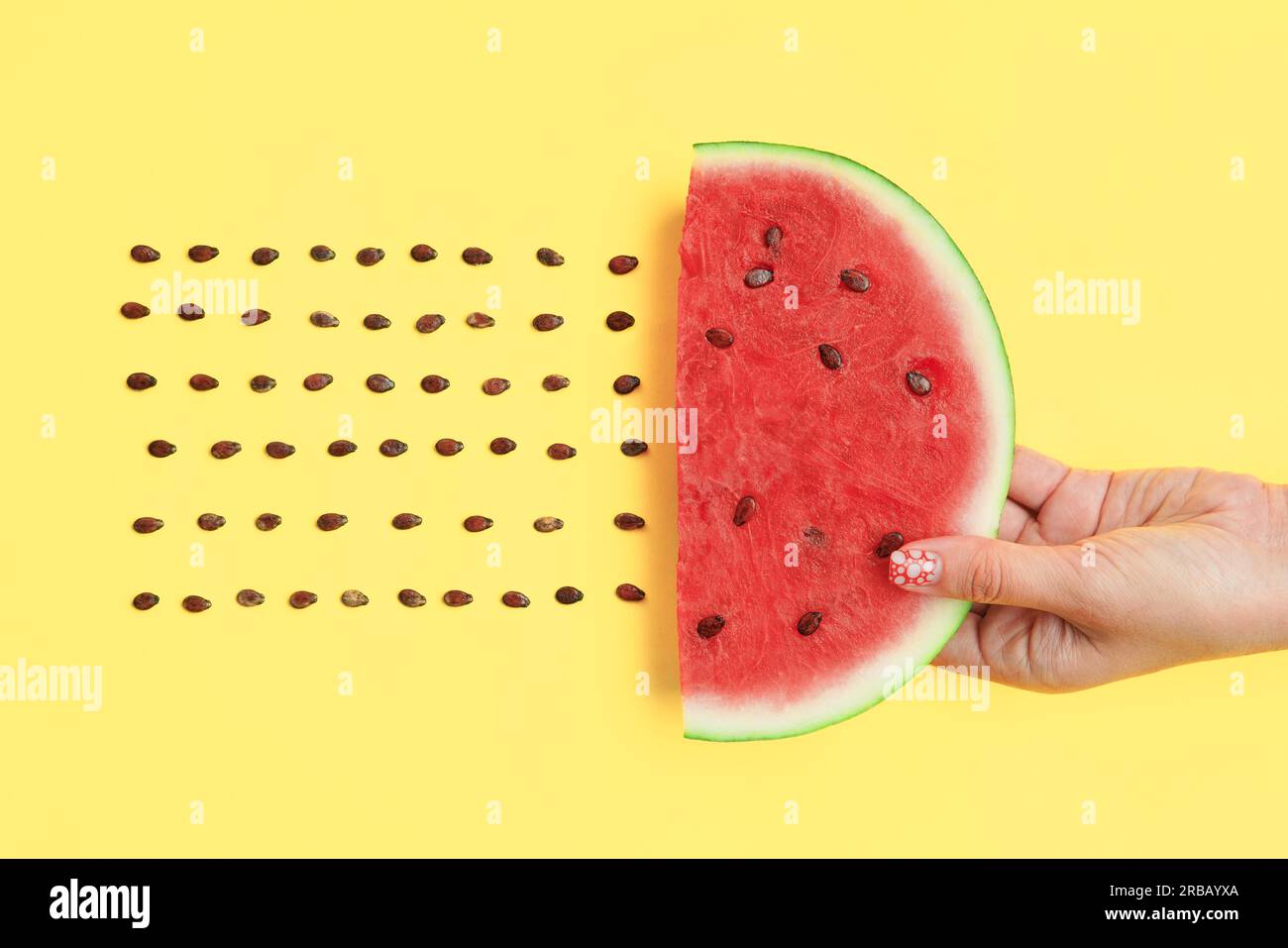 Wassermelone Scheibe mit Samen in den Händen auf gelbem Hintergrund. Lebensmittel Kunst. Flach legen Stockfoto