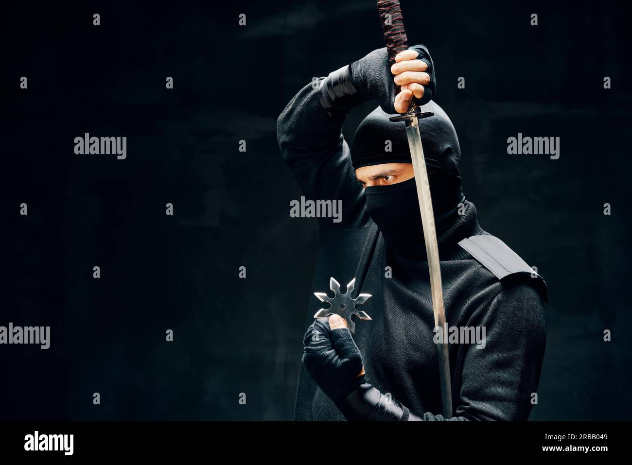 Ninja Samurai Krieger Kämpfer mit einem Schwert und shuriken über schwarzem Hintergrund. japanische Kämpfer Konzept Stockfoto