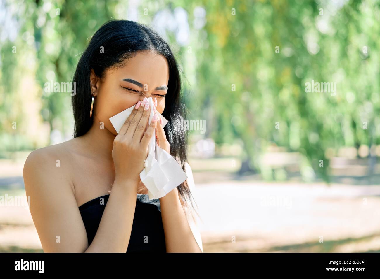 afroamerikanische Frau bläst ihre Nase in ein Gewebe. Allergie, Krankheit, Krankheit Konzept Stockfoto