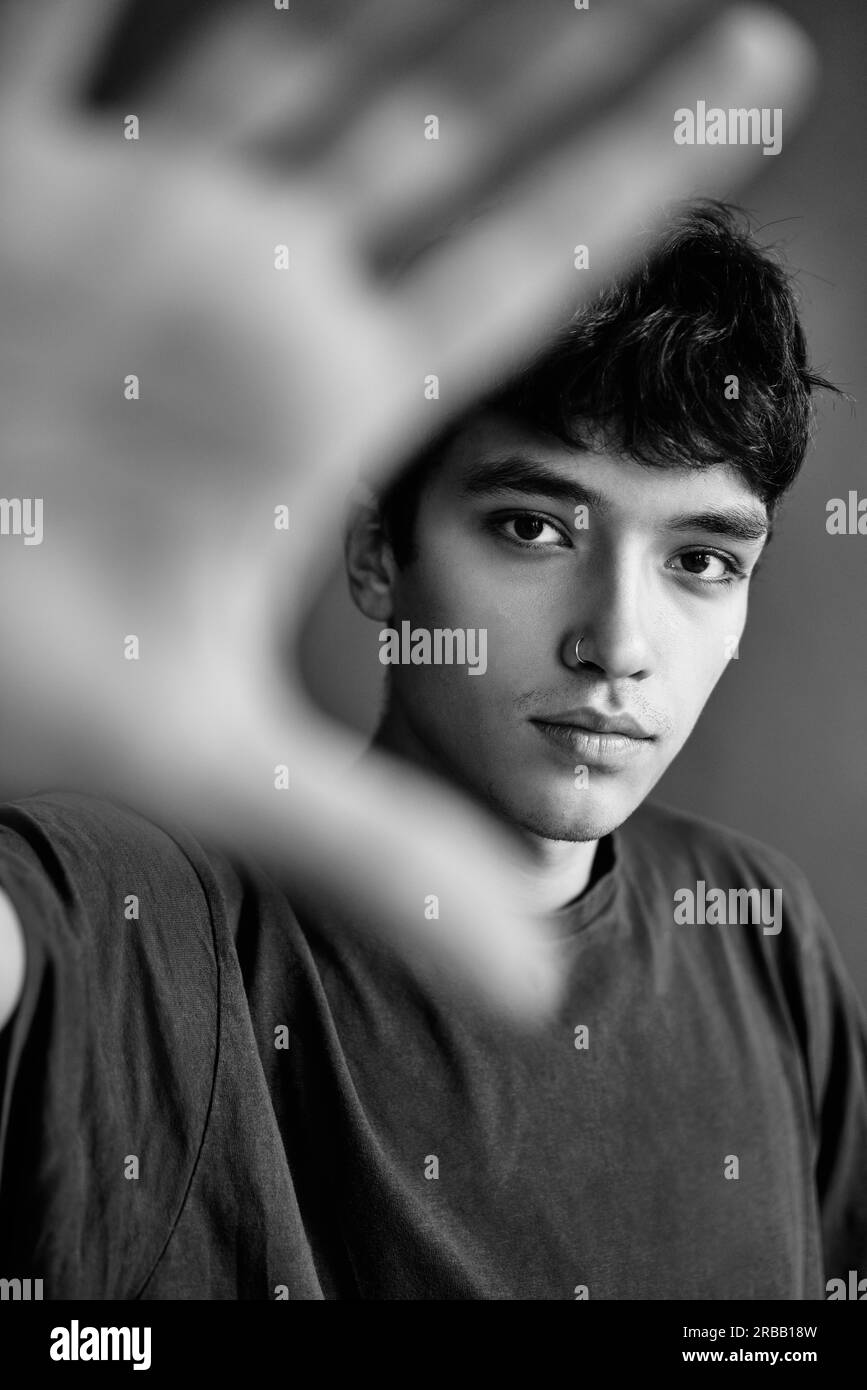 Schwarz-Weiß-Foto von schönen jungen Mann ausgestreckte Hand Und zeigt das Stoppschild an Stockfoto