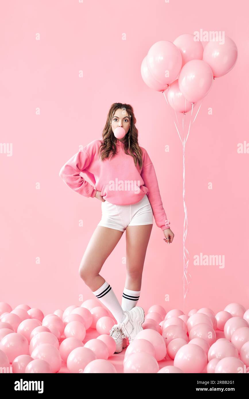 Blase aus Kaugummi. Teenager-Mädchen posiert auf rosa Hintergrund Stockfoto