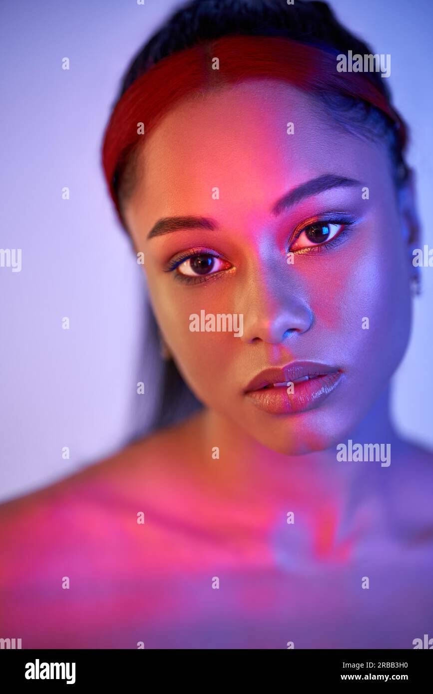 Nahaufnahme Porträt der hübschen afroamerikanischen Frau in hellen Neonlicht posiert auf Studio-Hintergrund. Modefotokonzept Stockfoto