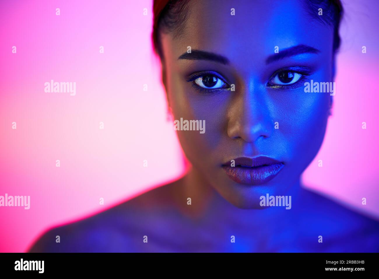 Nahaufnahme Porträt der hübschen afroamerikanischen Frau in hellen Neonlicht posiert auf Studio-Hintergrund. Modefotokonzept Stockfoto