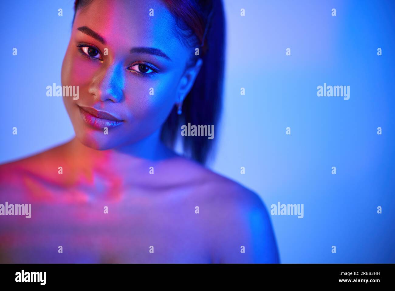 Neonlicht-Studioportrait einer hübschen afroamerikanischen Frau mit Kopierraum. Mode Foto, weibliche Schönheit Konzept Stockfoto