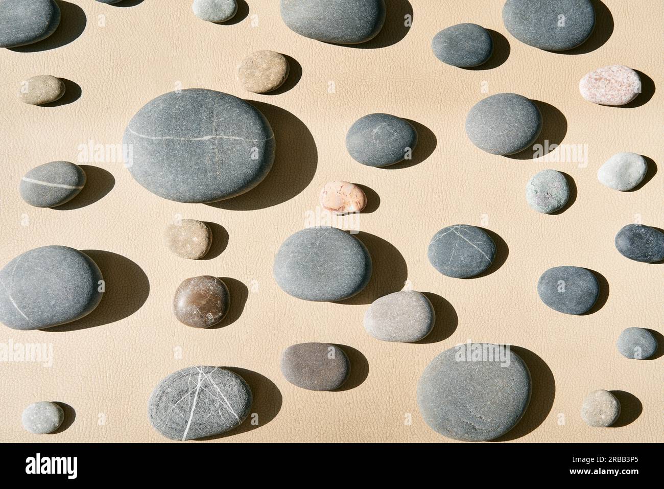Hintergrund der Steinwandtextur. Verschiedene Arten von Kieselsteinen vor hellem Hintergrund Stockfoto