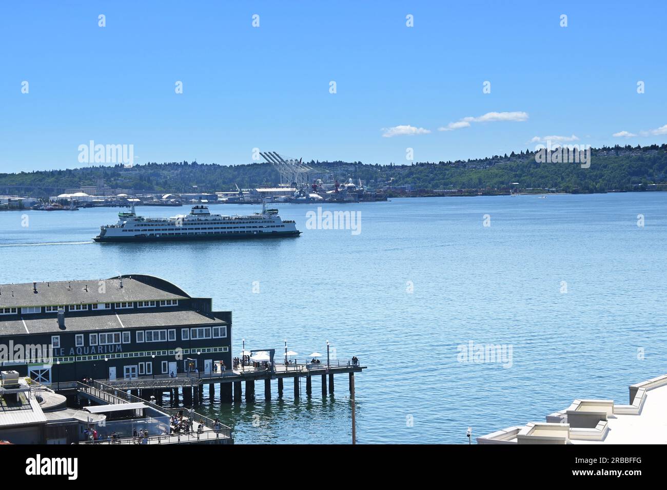 SEATTLE, WASHINGTON - 30. JUNI 2023: Das Seattle Aquarium mit einer Fähre auf dem Puget Sound. Stockfoto