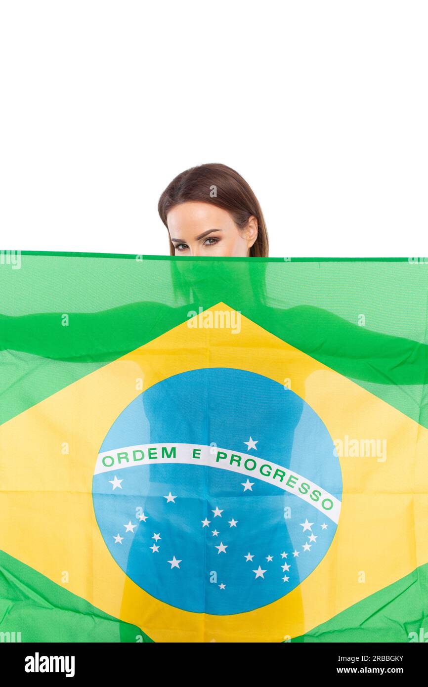 Junge Frau, die Körper und Gesicht durch die brasilianische Flagge versteckt, isoliert auf Weiß Stockfoto