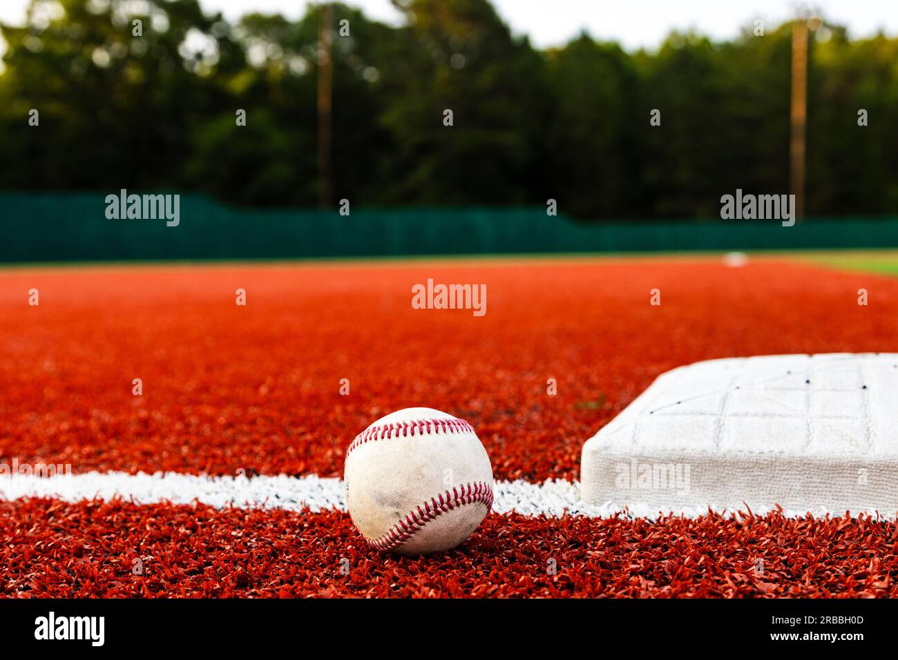 Baseball auf dem Feld neben der Basis für sportlichen Hintergrund mit Kopierbereich Stockfoto