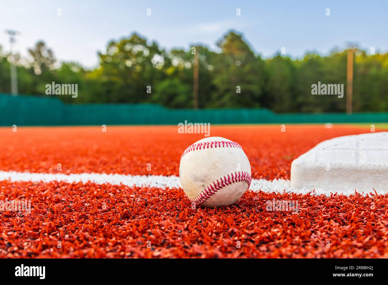 Baseball auf dem Feld neben der Basis für sportlichen Hintergrund mit Kopierbereich Stockfoto