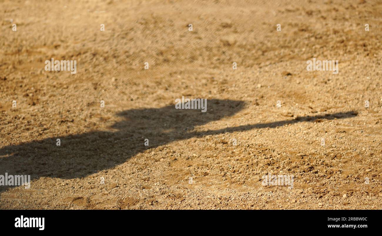 Schatten auf dem Innenfeld eines Softballspielers, der einen Schläger hält Stockfoto