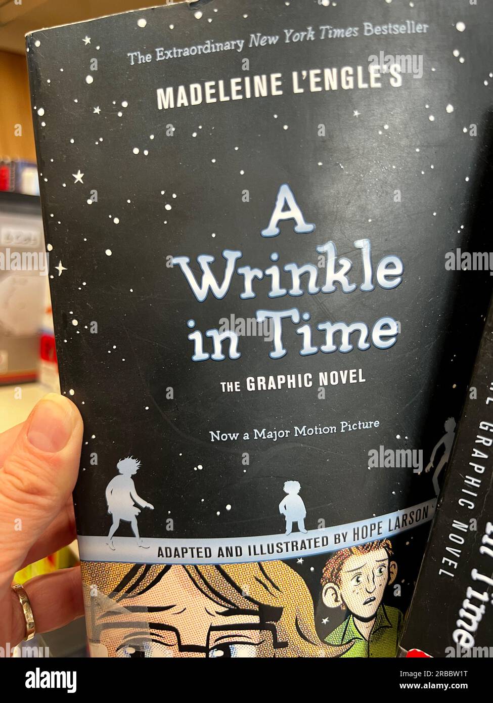 Eine Kopie der Romanversion von Madeleine L'Engle's A Wrinkle in Time, die vom Bücherregal gerissen wird Stockfoto
