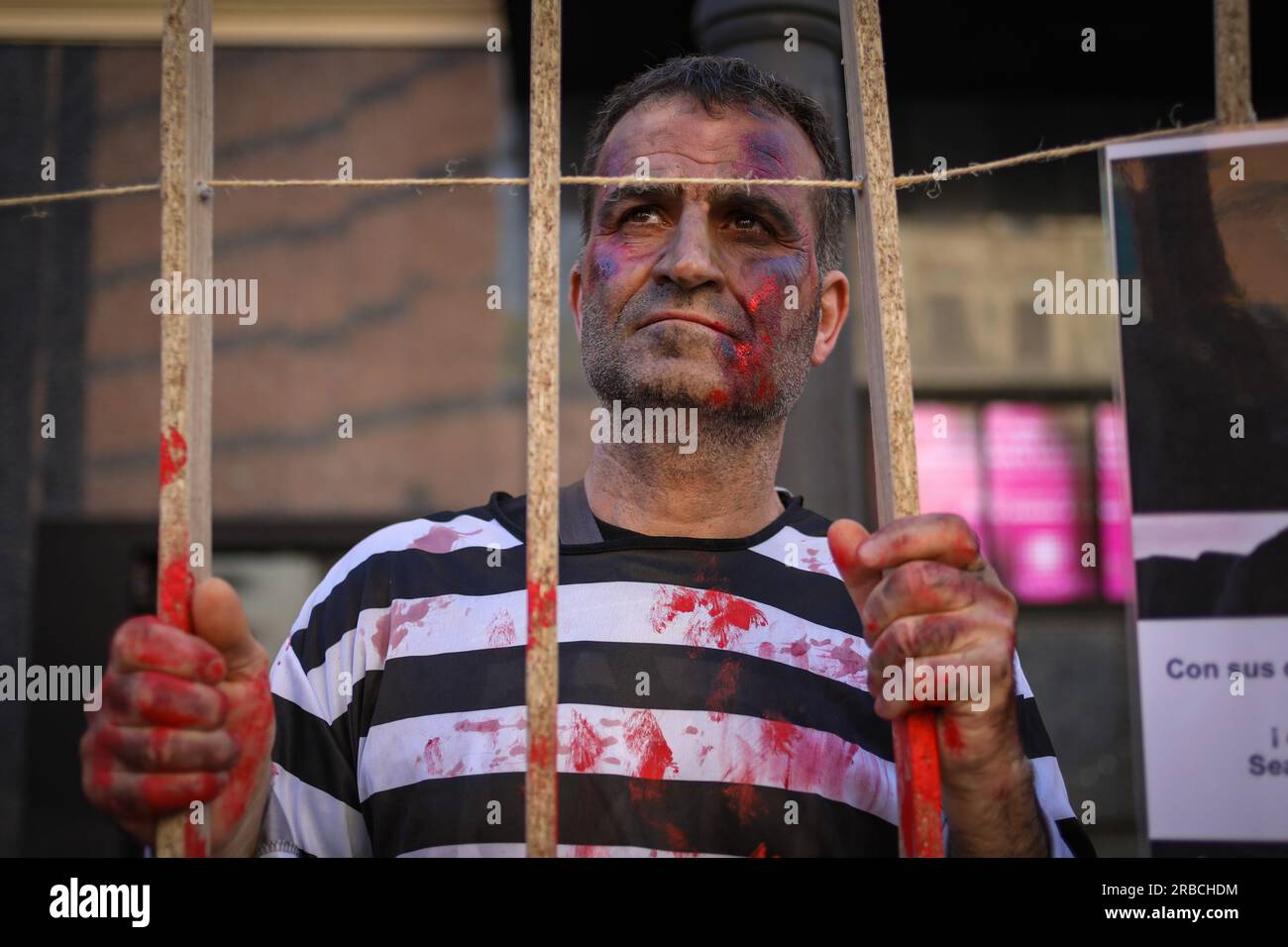 Madrid, Spanien. 08. Juli 2023. Ein als Gefangener verkleideter iranischer Aktivist vertritt den iranischen Künstler Toomaj, der während der Demonstration im Iran inhaftiert war. Eine Gruppe iranischer Einwohner, die in Madrid leben, traf sich am Nachmittag des 8. Juni auf der Plaza de Callao, um eine Leistung zur Unterstützung des iranischen Rappers Toomaj, der von der Regierung im persischen Land inhaftiert wurde, zu präsentieren und seine Freilassung zu fordern. Kredit: SOPA Images Limited/Alamy Live News Stockfoto