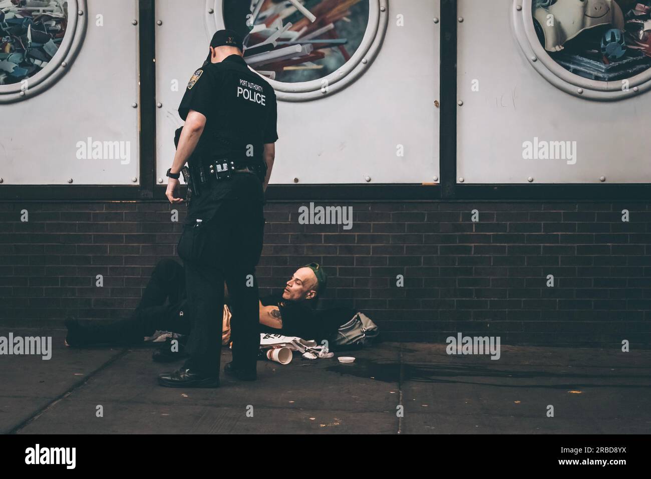 Ein Obdachloser, der von einem Polizisten verlegt wurde Stockfoto