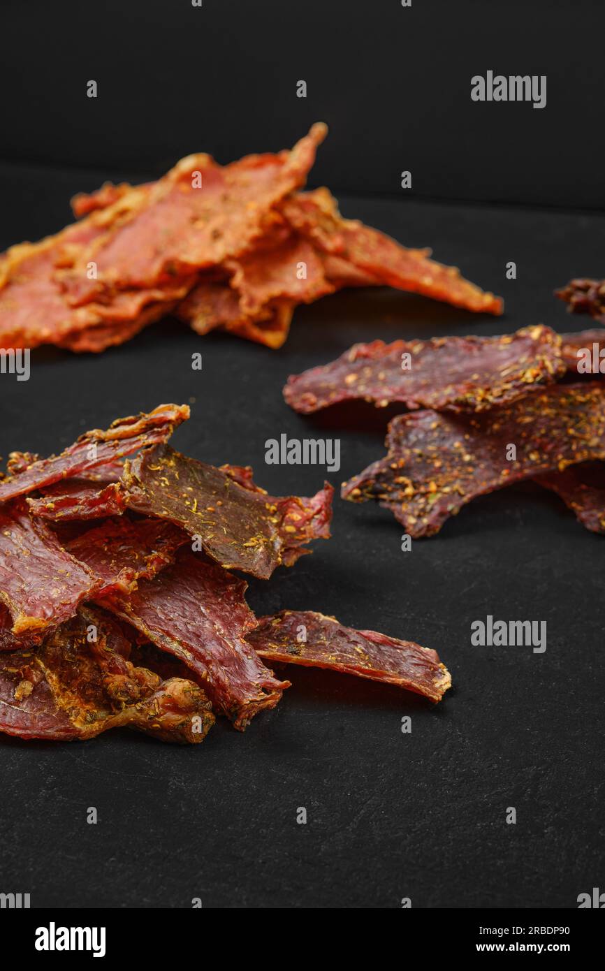 Verschiedene Arten von Trockenfleisch auf schwarzem Hintergrund Stockfoto
