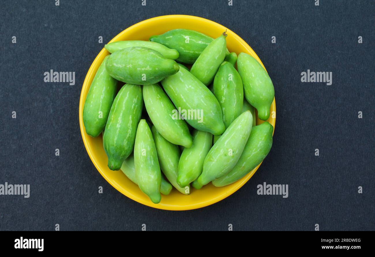 Ivy Gourds oder Coccinia grandis auf einem Teller auf schwarzem Hintergrund Stockfoto