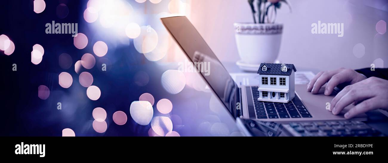 Das Konzept des Kaufs und Verkaufs von Immobilien. Ein Mann mit einem Modell eines Hauses im Hintergrund Stockfoto