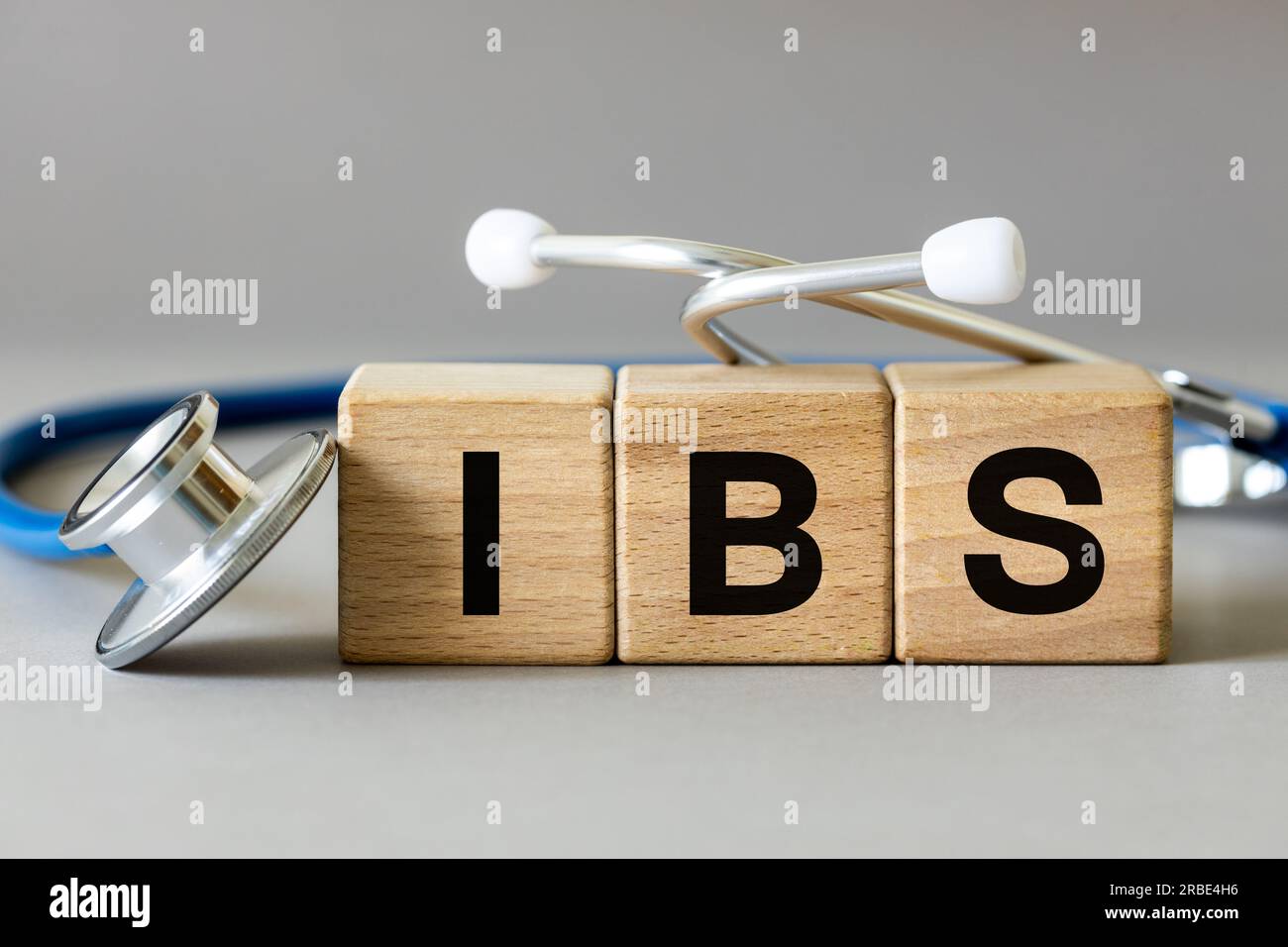 Medizinisches Stethoskop und Holzblöcke mit der Inschrift IBS, Abkürzung für Reizdarmsyndrom, eine chronische Erkrankung des Magen-Darm-Trakts Stockfoto