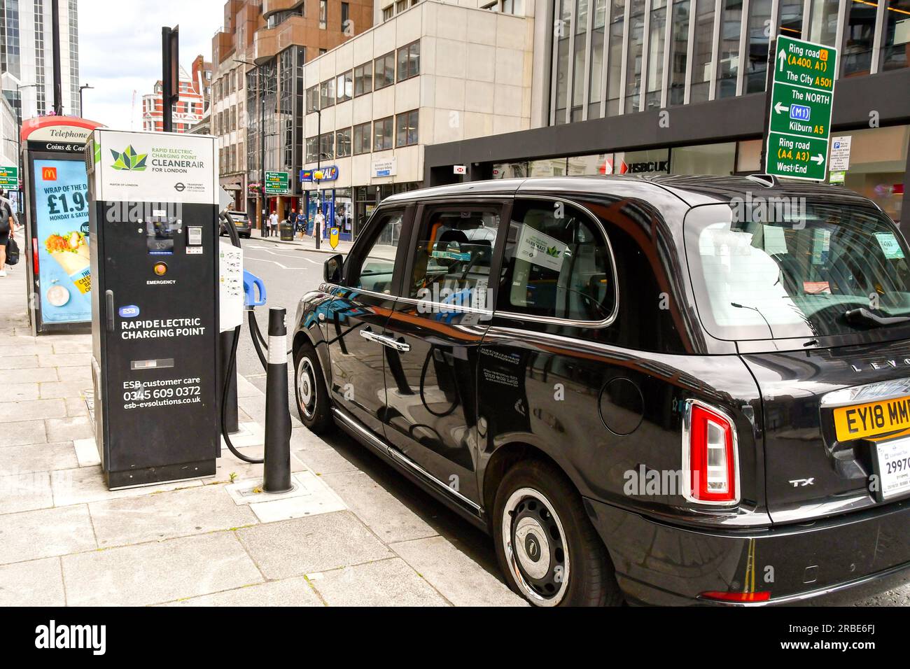 London, England, Vereinigtes Königreich - 27. Juni 2023: Elektrisches Taxi an Schnellladestation in einer Straße im Zentrum Londons angeschlossen Stockfoto