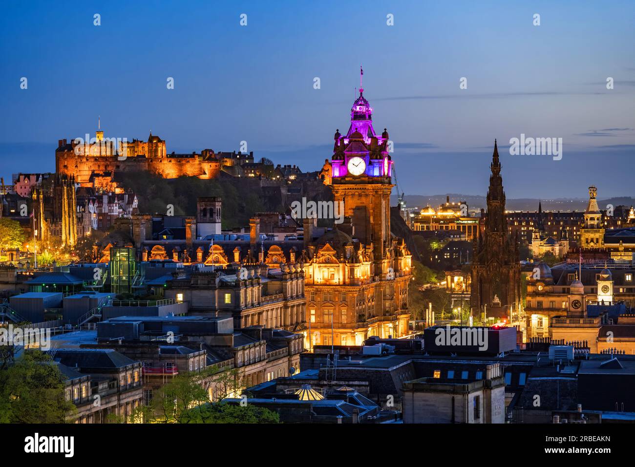 Skyline von Edinburgh bei Nacht in Schottland, Großbritannien. Abendliche Stadtlandschaft mit Edinburgh Castle, dem Uhrenturm des Balmoral Hotels und dem Scott Monument. Stockfoto