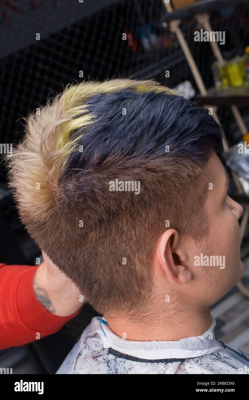 Junger Mann im Salon mit stilvoller, modischer Haarfarbe, kreativer Haarfarbe. Stockfoto