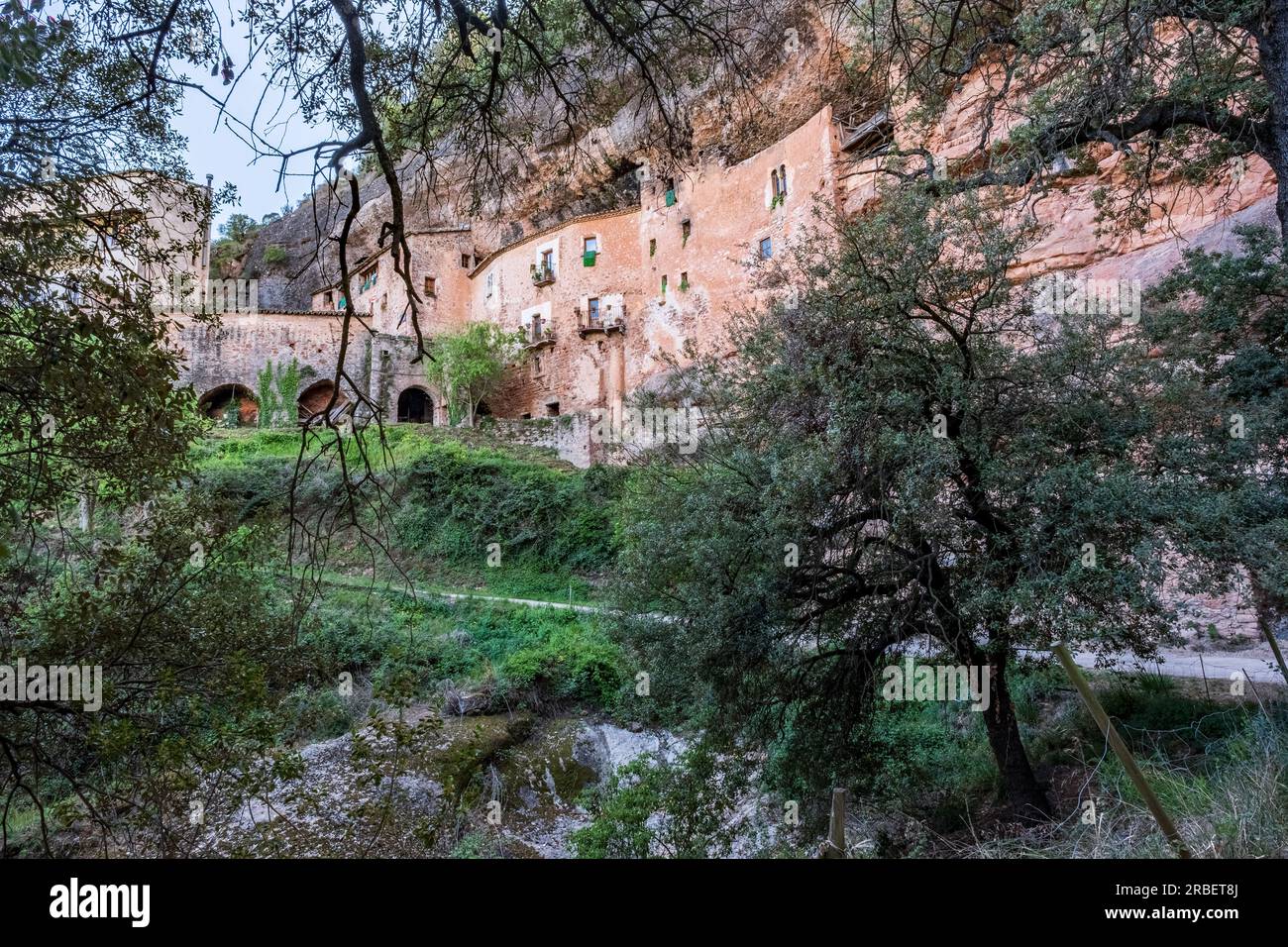 Gesamtblick auf Casal del Puig de la Balma, ein altes Bauernhaus aus dem 12. Jahrhundert, das in den Felsen gehauen wurde, ein Werk der Gemeinde Mura (Spanien) Stockfoto