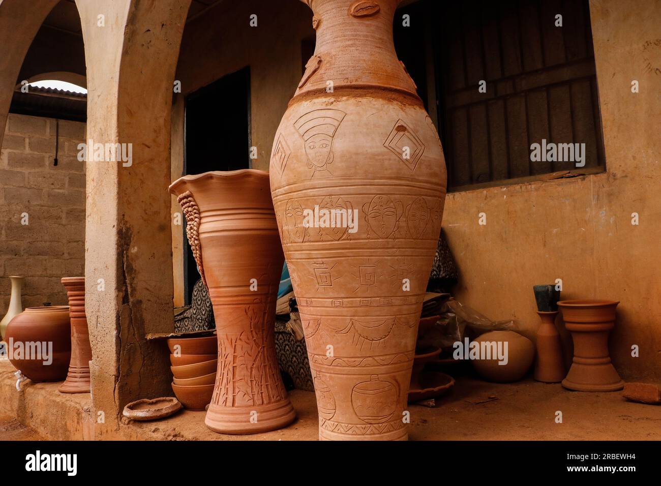 Die nigerianische Kunsthandwerkerin Olugbade Adekemi stellt in ihrer Töpferwerkstatt in einem Vorort von Lagos Tontöpfe mit traditionellen Methoden her. Der junge nigerianische Töpfer, der in der Keramikindustrie Wellen schlägt, bildet auch junge Menschen aus, zumeist Kunststudenten in höheren Einrichtungen, die während der Ferien zum Lernen kommen. Lagos, Nigeria. Stockfoto