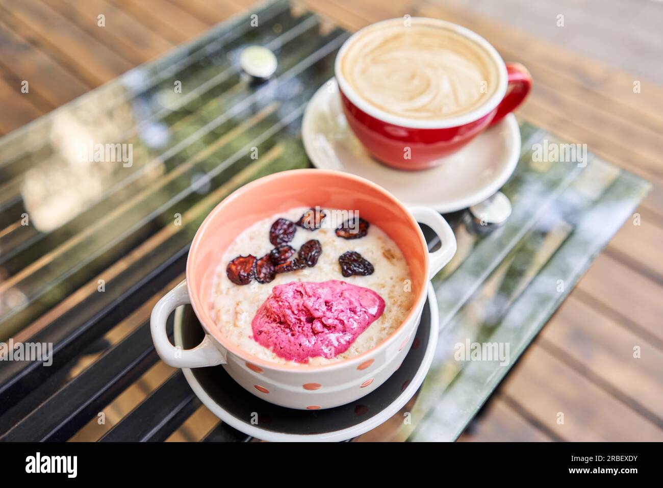 Frühstück mit frisch zubereitetem Haferbrei, serviert mit trockener Kirsche und Erdbeersorbet in der Schüssel. Müsli, köstliches Frühstück, Diät-Frühstück. Eine Tasse Stockfoto