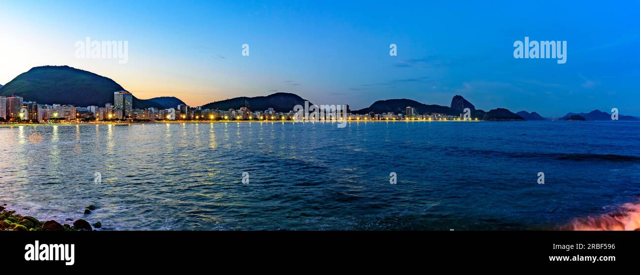 Abenddämmerung am Copacabana-Strand in Rio de Janeiro mit dem Meer und dem Zuckerhut Stockfoto