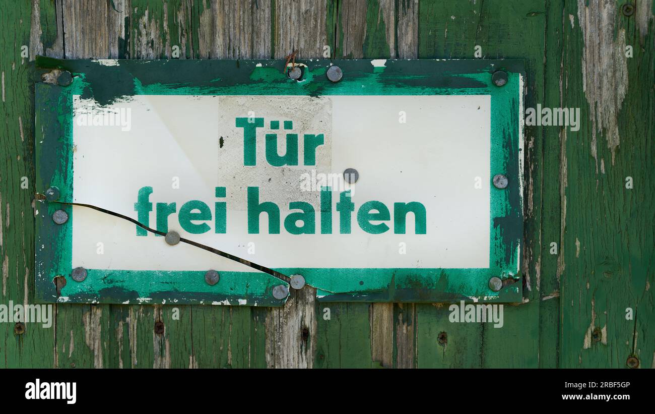 Schild am Garagentor mit deutscher Aufschrift Tuer frei halten. Übersetzung: Tür frei halten Stockfoto