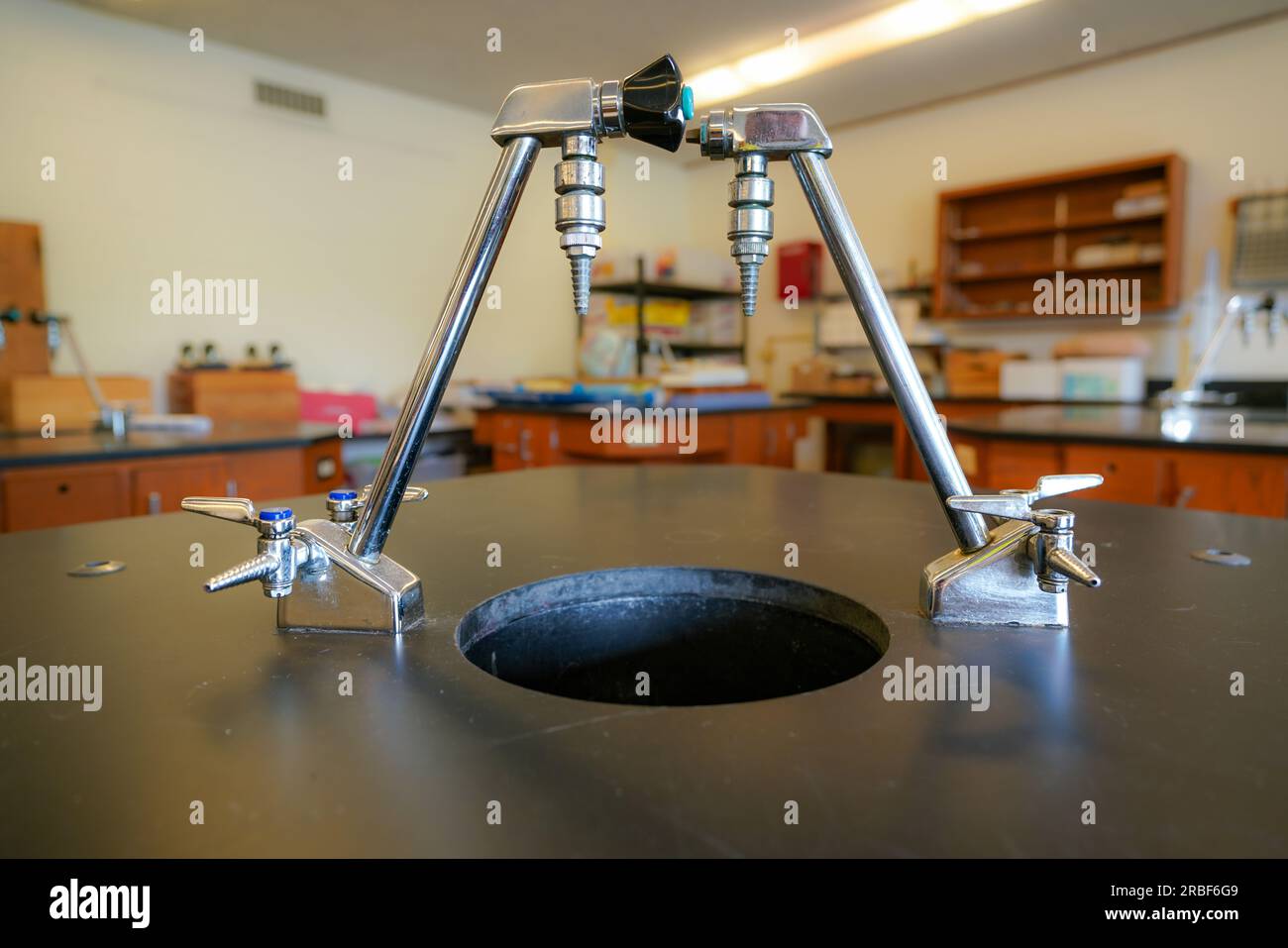 Kolben auf einem schwarzen Kunststofftisch mit einem Highschool-Wissenschaftsraum-Hintergrund. Stockfoto