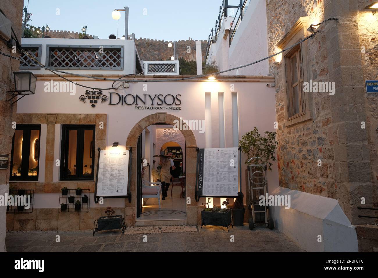 Blick auf den Eingang des Restaurants Dionysos in der Altstadt von Lindos. Stockfoto