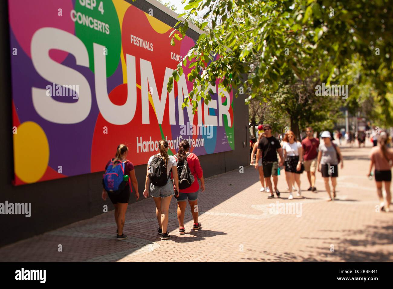 Leute, die auf dem Bürgersteig am Hafen von Toronto spazieren gehen Stockfoto
