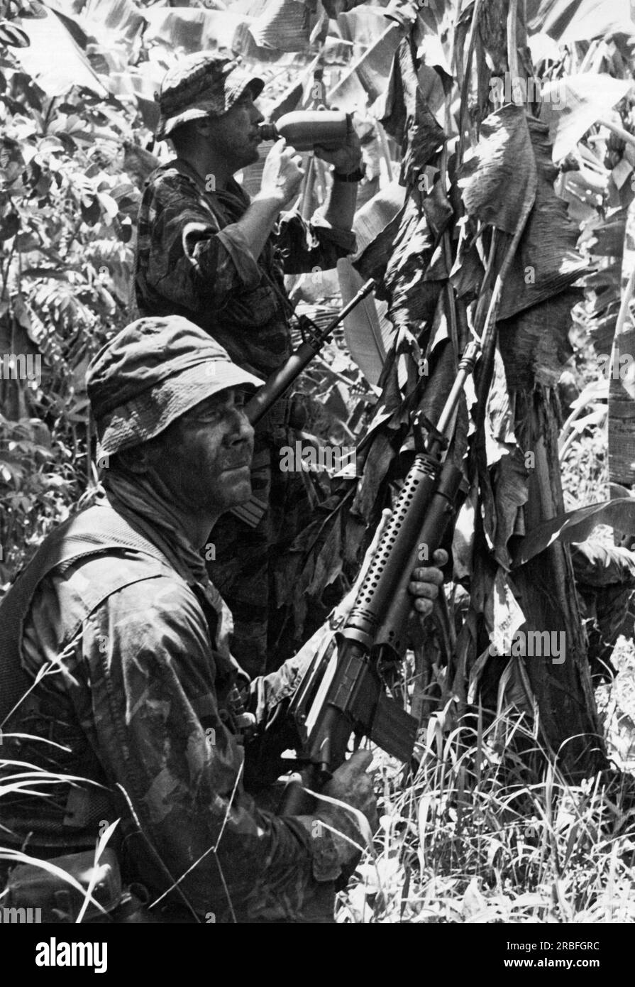 Vietnam: Dezember 1967 zwei Navy Seals halten während der Operation Crimson Tide in der Provinz Vinh Binh südwestlich von Saigon für einen Drink Wasser. Stockfoto