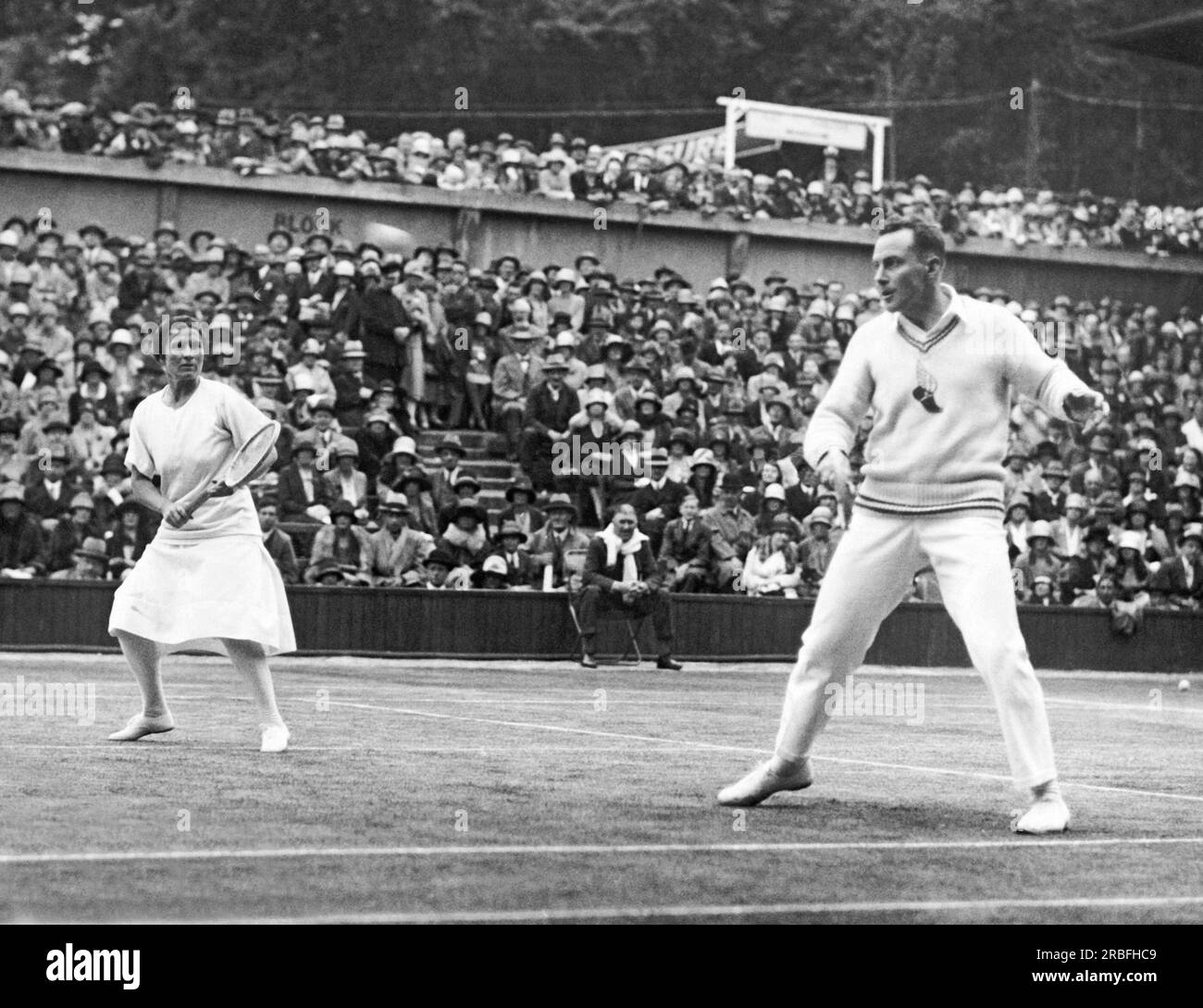 London, England: 1927 Amerikaner Elizabeth Ryan und Frank Hunter spielen gegen das britische Team bei den Rasentennismeisterschaften in Wimbledon. Sie gewannen die Mixed-Doubles-Meisterschaft. Stockfoto