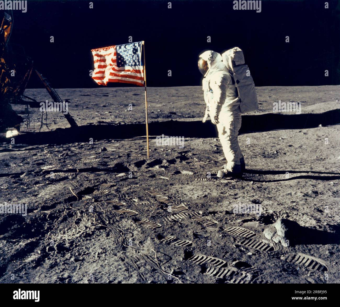 Mond: 20. Juli 1969 Astronaut Edwin „Buzz“ Aldrin, Pilot des Mondmoduls, posiert während der Mondlandung von Apollo 11 neben der Flagge der Vereinigten Staaten. Das Lunar Modul 'Eagle' befindet sich auf der linken Seite. Commander Neil Armstrong hat das Foto gemacht. Stockfoto