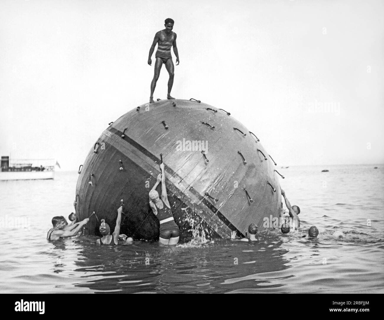 Catalina Island, Kalifornien: c. 1935 das Neueste in Sachen Wasserunterhaltung im Avalon auf Catalina Island ist ein vierzehnfüßiger Ball, der in zwei Farben gemalt ist. Ziel ist es, die Farbe deines Teams über Wasser zu bringen. Stockfoto