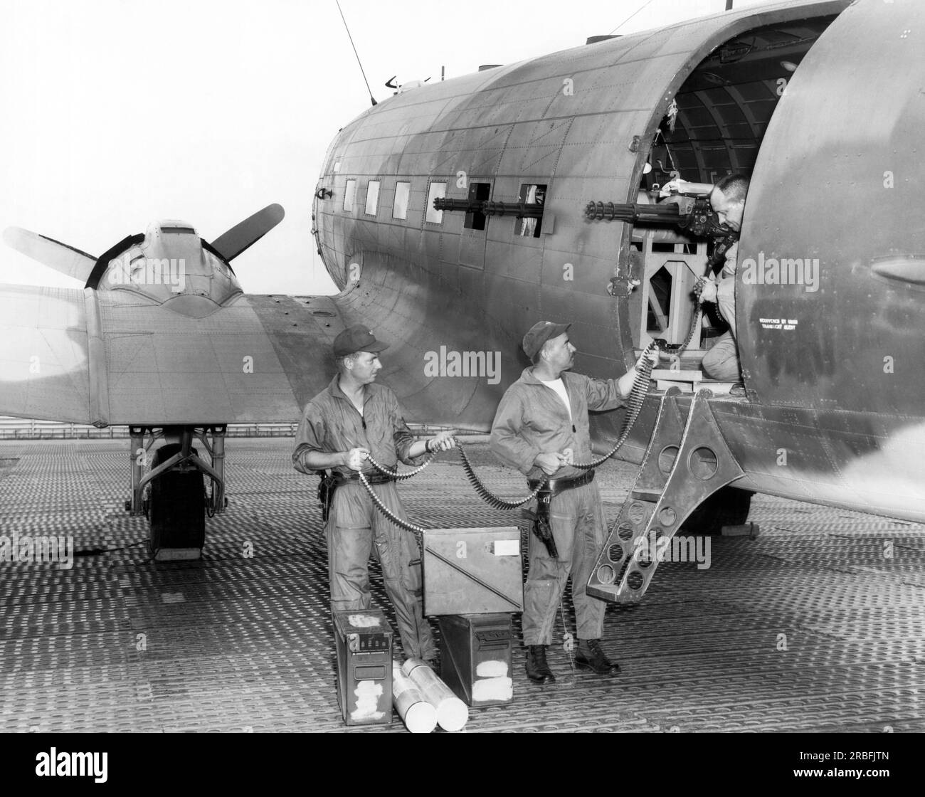 Saigon, Vietnam: 1966 Flugzeuge laden Munition in eine der drei 7,62mm Kanonen, die an der Seite eines Air Force Douglas AC-47 Dragon-Schiffs montiert sind. Die Kanonen feuern bis zu 18.000 Schuss pro Minute, und die Leuchtsignale, Flammen und der rote Phosphor, der vom Kanonenschiff kam, waren so fantastisch, dass der Vietcong sie Drachenschiffe nannte. Stockfoto