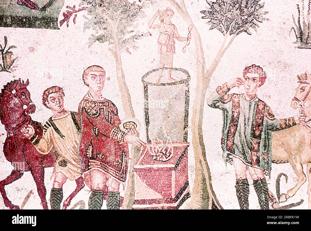 Dieses Foto eines Mosaiks, das eine kleine Jagdszene zeigt, die Artemis, die Seltsamkeit der Jagd (auch bekannt als Diana), opferte, wurde im Sommer 1970 auf der Piazza Armerina in Sizilien aufgenommen. Die Piazza Armerina beherbergt die römische Villa del Casale und ihre berühmten Mosaiken, die „besten Mosaike in situ in der römischen Welt“, wie von der UNESCO beschrieben, die sie 1997 in ihre Liste des Weltkulturerbes aufgenommen hat. Villa Romana war eine üppige Patrizier-Residenz, die im Zentrum eines riesigen Latifundiums (Landwirtschaftsgelände) am Ende des 4. Jahrhunderts n. Chr. erbaut wurde. Es wird angenommen, dass es einem Mitglied der Roma gehört hat Stockfoto