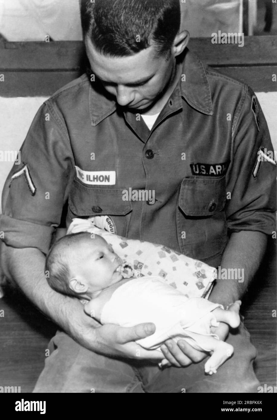 Saigon, Vietnam: 8. August 1966 Ein Privatmann der 120. Aviation Company verbringt seine Freizeit mit den 800 Kindern im Go VAP Waisenhaus außerhalb von Saigon. Stockfoto