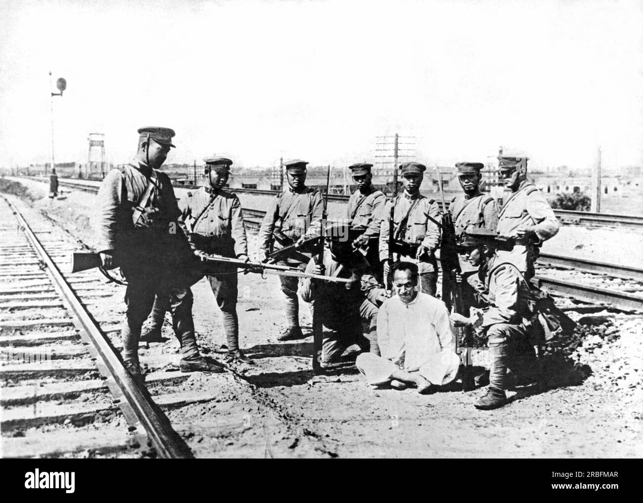 Mukden, Mandschurei: ca. 1933. Japanische Truppen befragen einen Gefangenen Chinesen in der Mandschurei nach Informationen über die flüchtenden chinesischen Truppen. Es wird berichtet, dass dieser chinesische Staatsbürger nach diesem Foto gefoltert wurde. Stockfoto