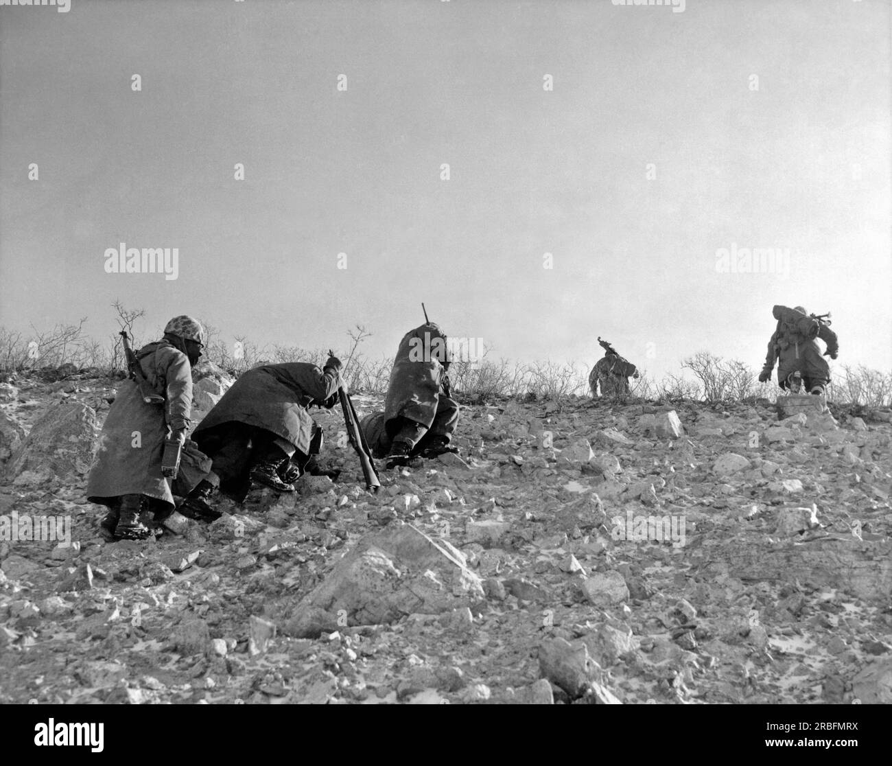 Koto-ri, Korea: Dezember 1950. Eine Patrouille der Siebten Marine kämpft sich den Weg hinauf auf einen gefrorenen Berg, um die chinesischen Kommunisten zu flankieren, die versuchen, den Rückzug der Marine aus dem Chosin-Reservoir südlich von Koto-ri in die Falle zu locken. Stockfoto