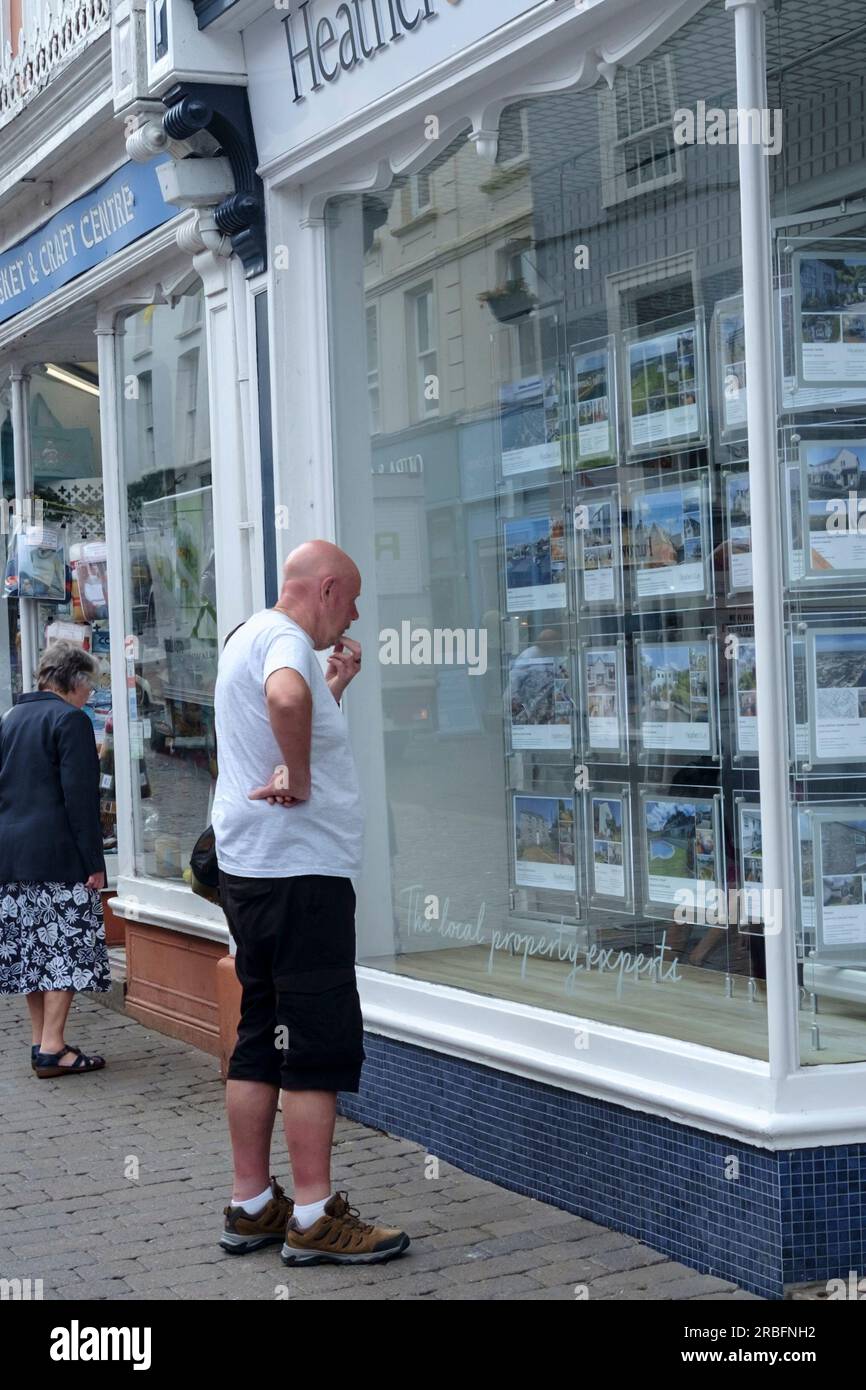 In der Nähe von Falmouth, einer beliebten Stadt in Cornwall, Großbritannien. Ein Mann schaut auf ein Maklerfenster. Stockfoto