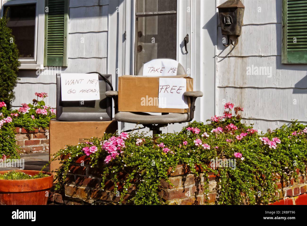 Alte Computerausstattung - verpackt mit altmodischem Monitor und verblasstem Bürostuhl zum Verschenken auf der Veranda des Hauses - Schilder mit der Aufschrift "Free and Take Me" Stockfoto