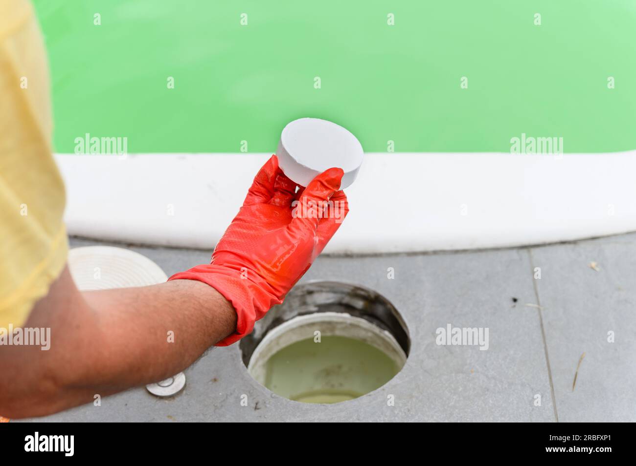 Schwimmbadservice und Ausrüstung mit chemischen Reinigungsprodukten. Ein Mann bedient den Pool und ersetzt die Tafel. Stockfoto