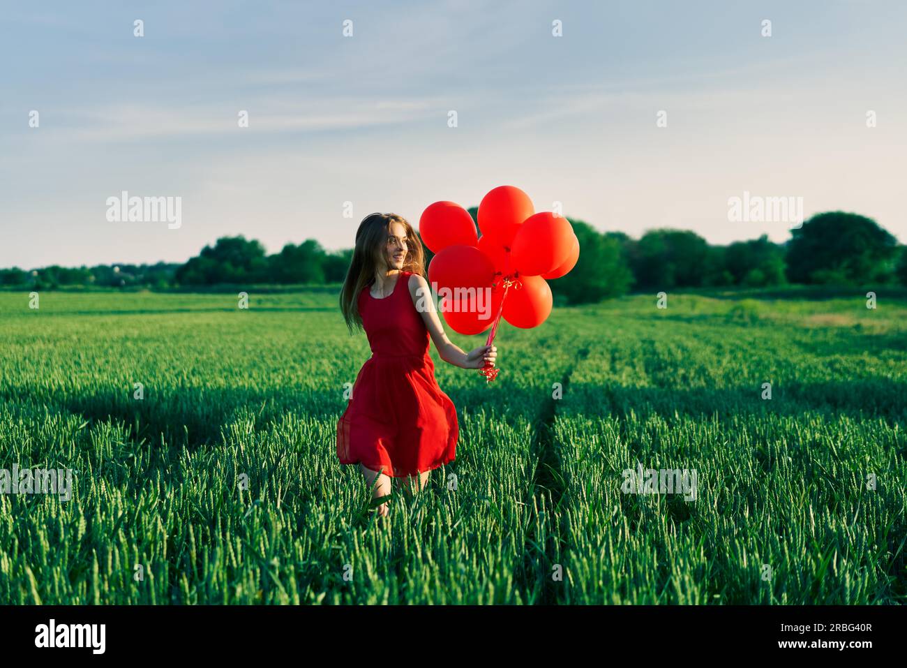 Freiheit glücklich Frau mit roten Ballons auf grün sommer feld. Spaß, Glück Konzept Stockfoto