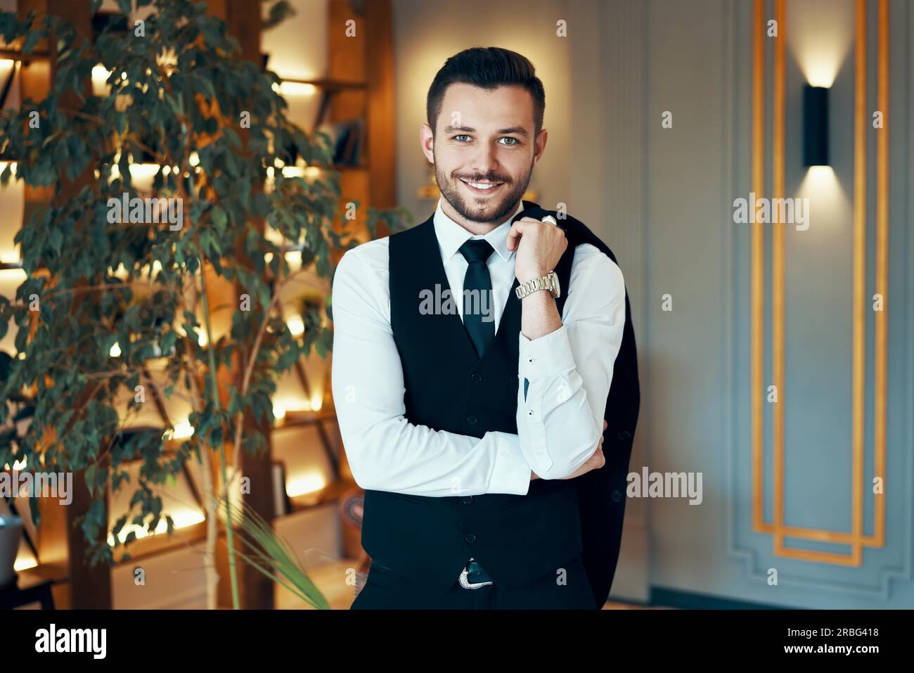 Gerne schöner Mann im eleganten Anzug in moderner Luxus Interieur. Mode portrait Stockfoto