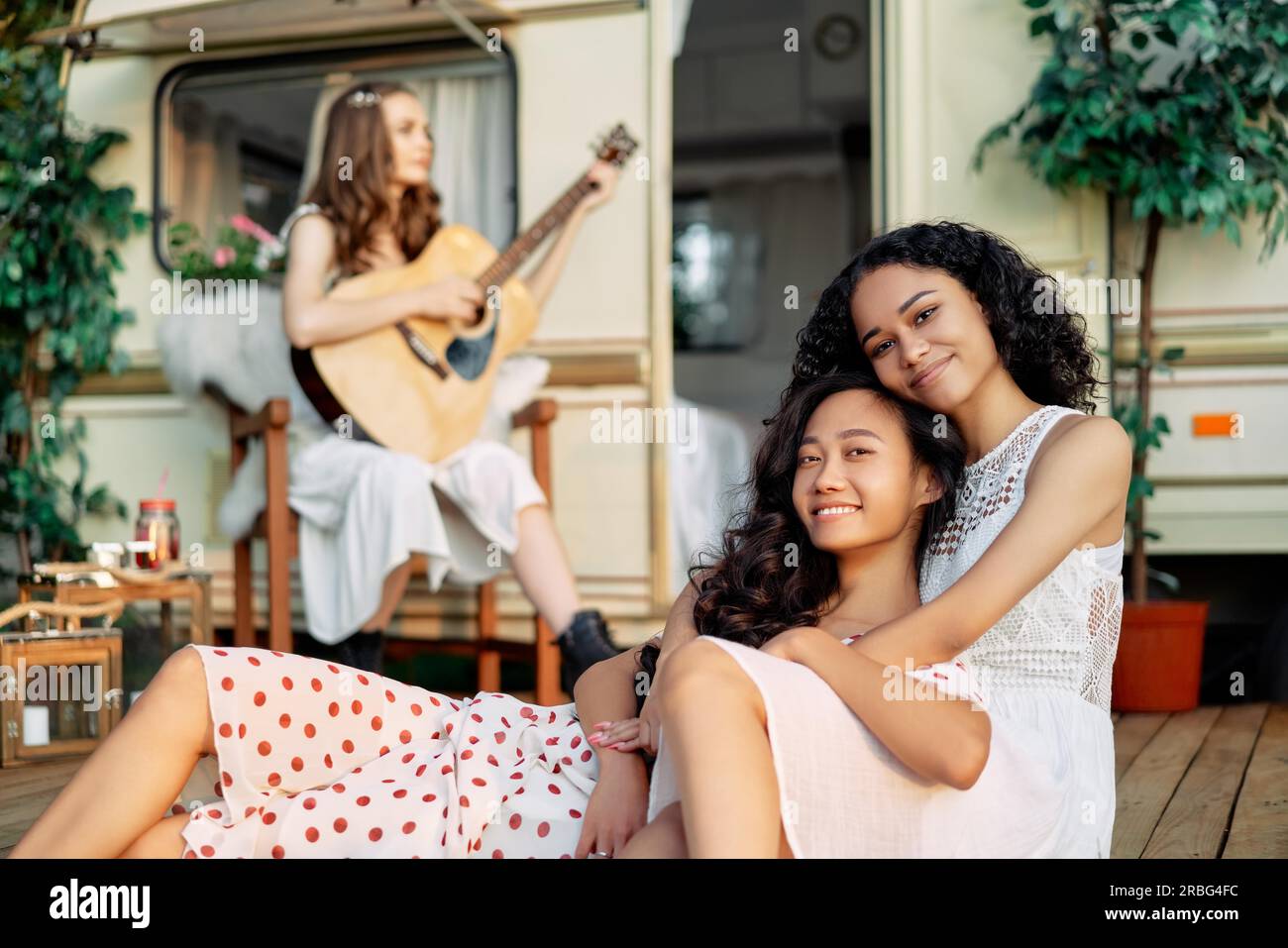 Junge glückliche Frauen entspannen sich und haben Spaß im Sommerurlaub. Asiatische und afroamerikanische Frau, die sich umarmt. Frauenfreundschaftskonzept Stockfoto