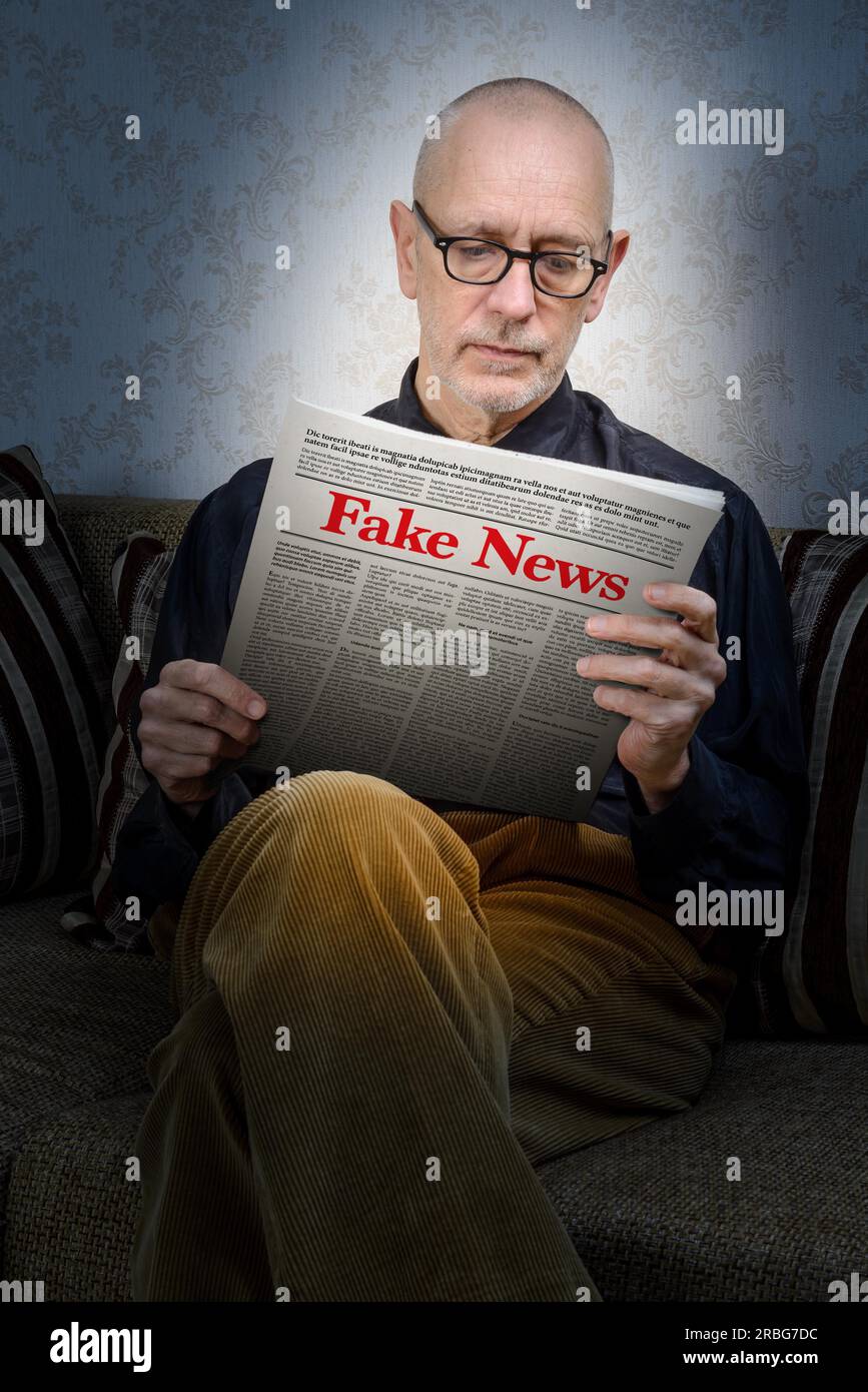 Ein Mann mit Brille sitzt zu Hause auf einer Couch und liest eine Zeitung, die falsche Nachrichten meldet. Falscher Lorem-ipsum-Text Stockfoto